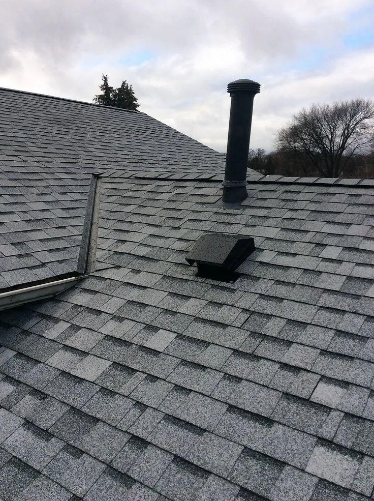 Finished grey architectural shingle roof in Barrhaven with a box vent and plumbing stack