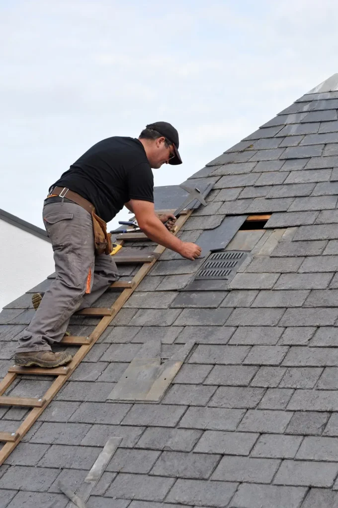 Roofer replacing broken slates on a roof in Nepean